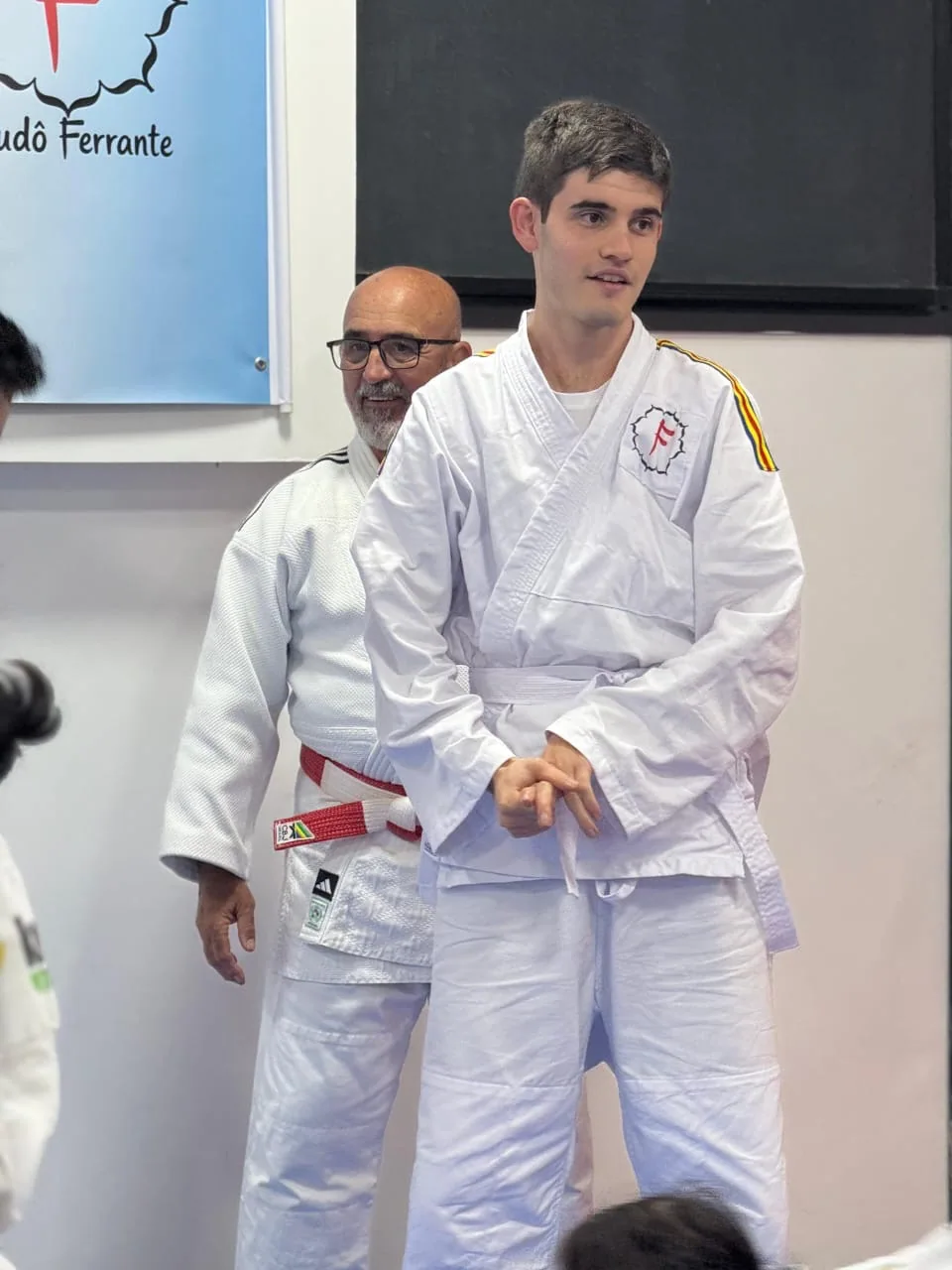 Judoca do projeto participando de cerimônia com apoio da equipe, no seu próprio ritmo
